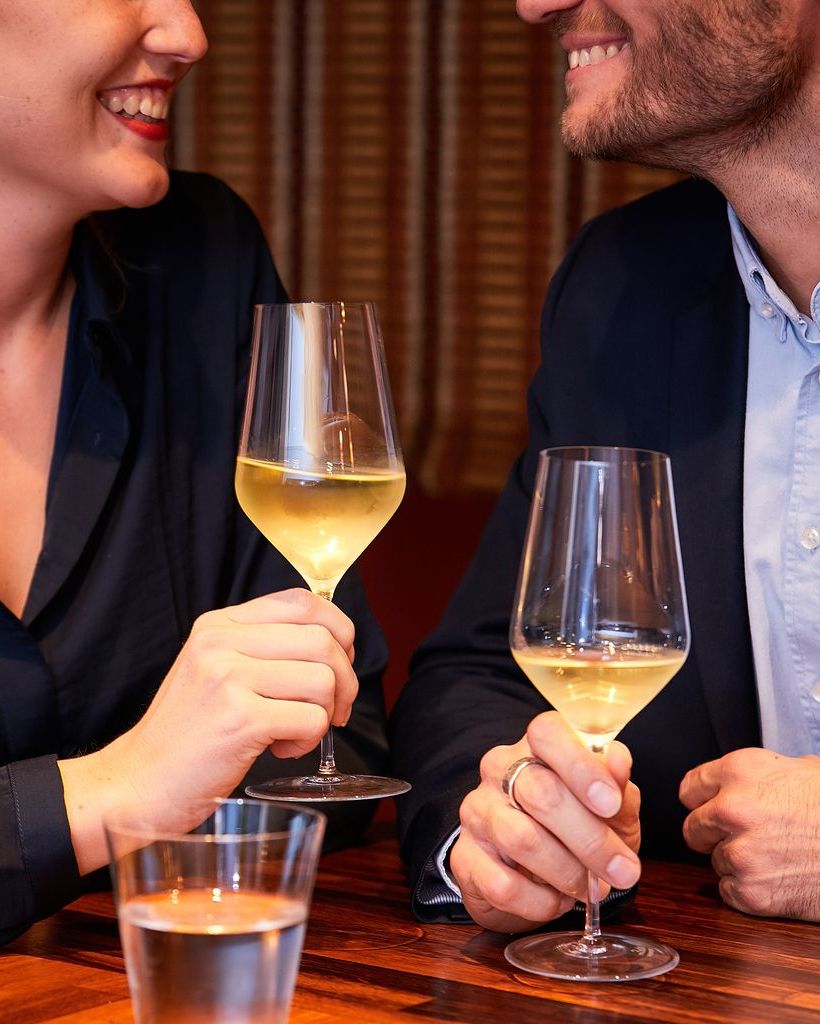 Two people enjoying white wine from Zalto White Wine glasses at a restaurant table